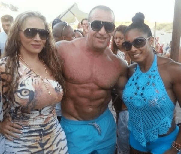 bodybuilder posing with women